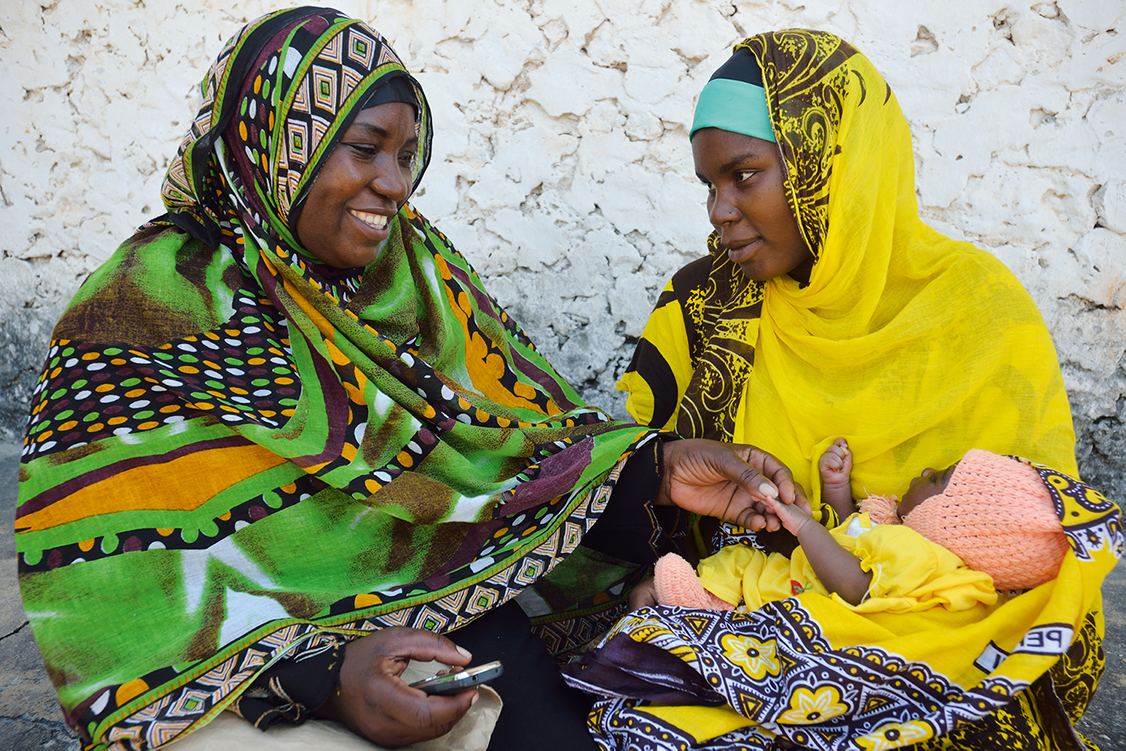 A community health volunteer in Zanzibar, guided by a mobile phone tool, counsels a new mother